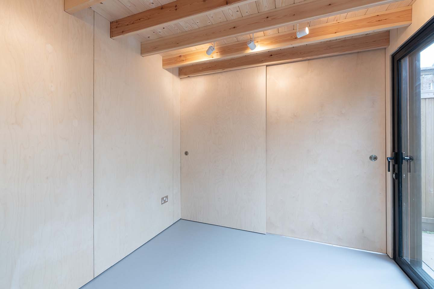 Interior plywood cladding with sliding doors and hidden storage